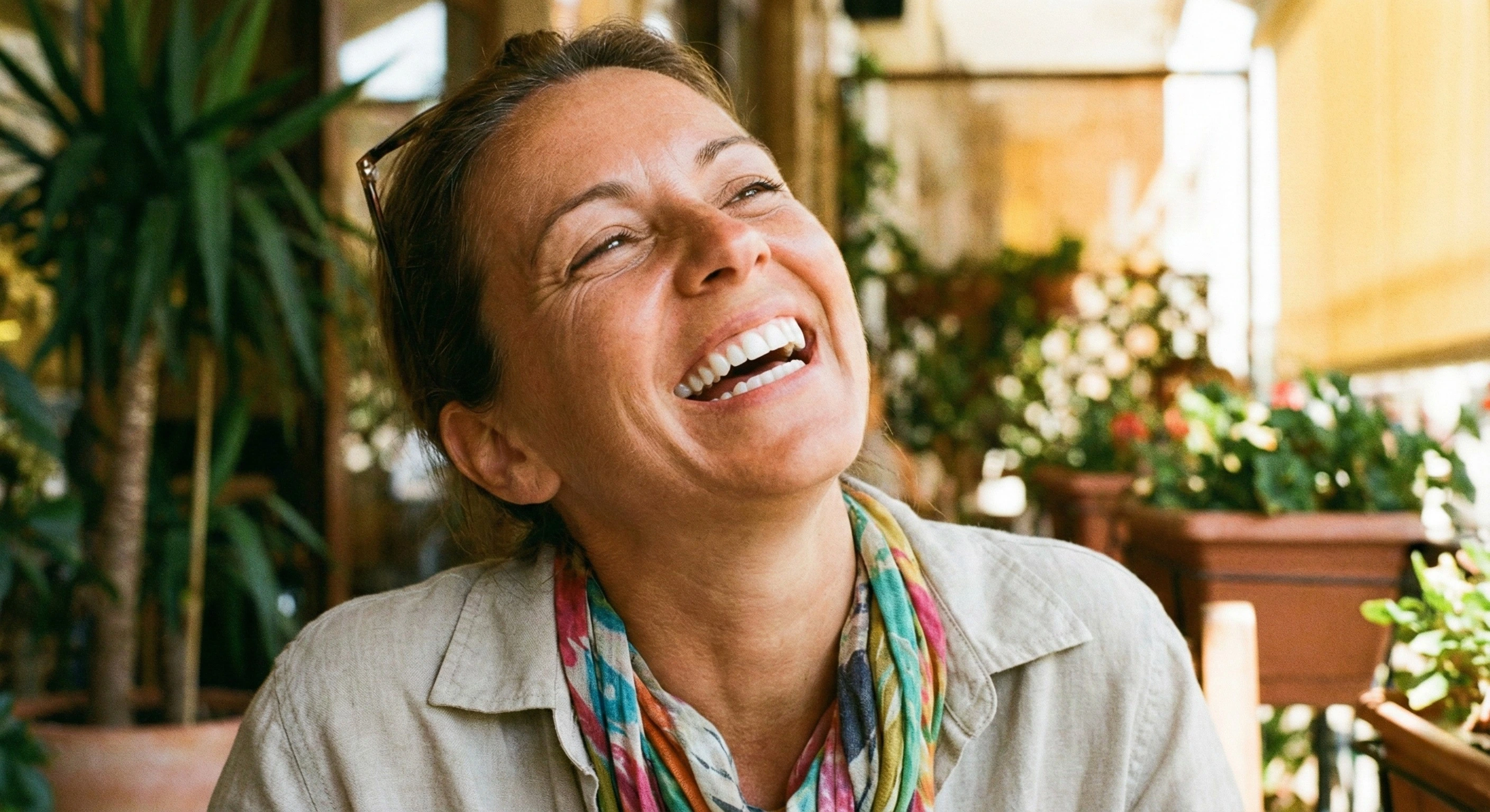 Donna di 42 anni che ride felice mostrando denti bianchi e luminosi, senza coprirsi la bocca